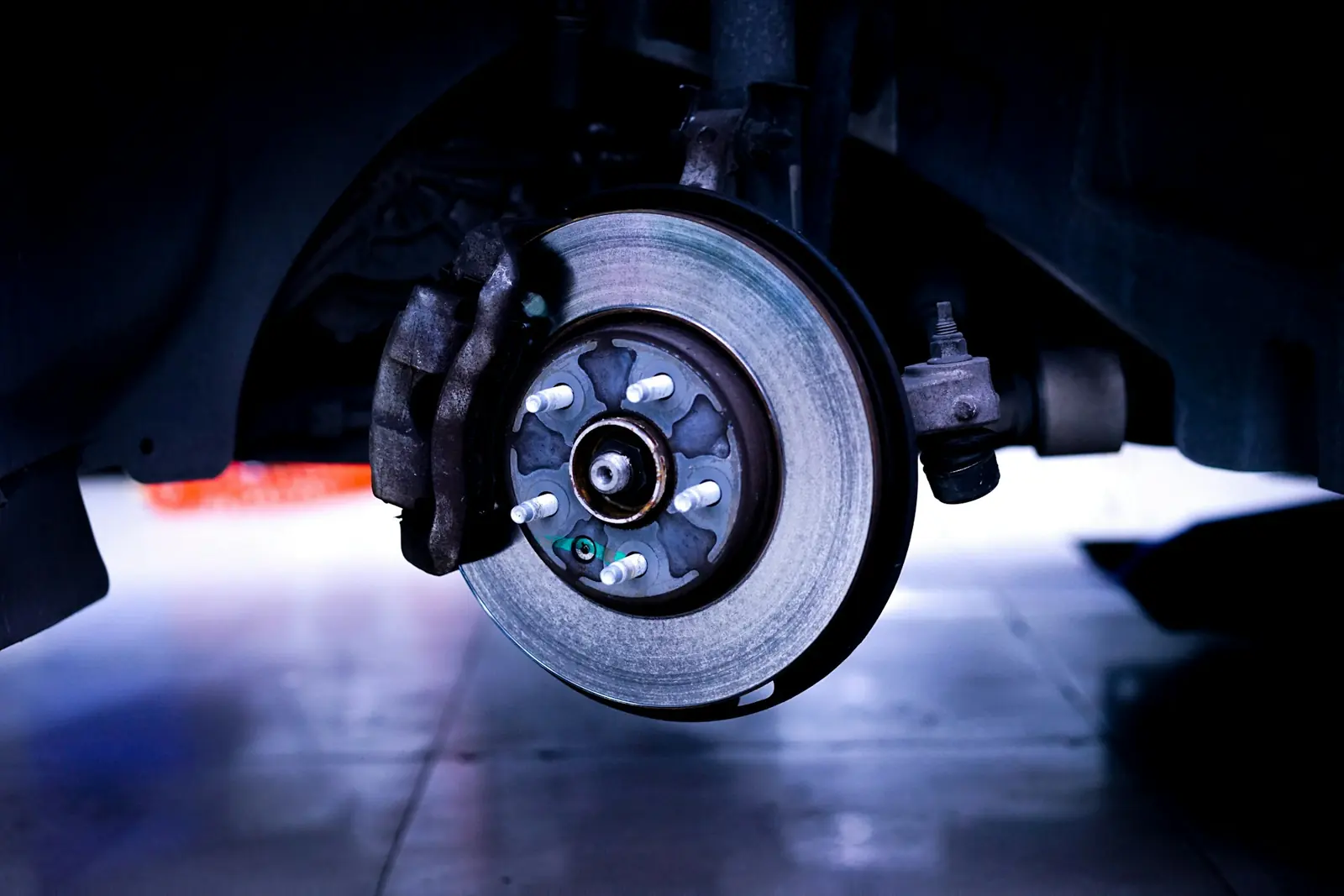 Brake rotor and caliper close-up under blue light